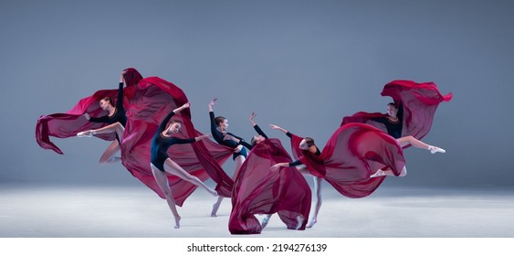 Portrait of young ballerina dancing with deep red clored fabric isolated over blue grey studio background. Flower bloom. Art style. Concept of classic ballet, inspiration, beauty, dance, creativity - Powered by Shutterstock