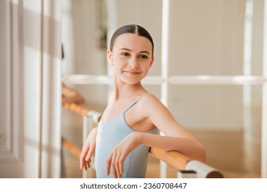 portrait of young ballerina in studio. happy young ballerina exercising in the barre. Young pretty ballet dancer. - Powered by Shutterstock