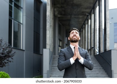 Portrait Young Bearded Businessman Begs God For Success With Hope Raising His Hands Up To Sky. Business Man Asks For Luck And Prays For A Successful Solution Asking For Help.