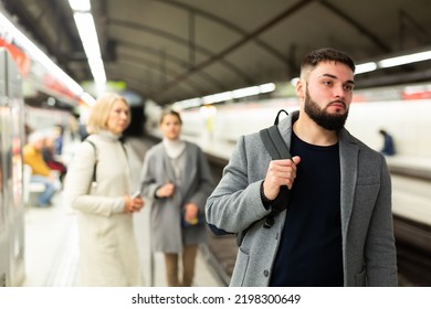 Portrait Of Young Bearded Man Waiting For Train In Crowded Subway Station..
