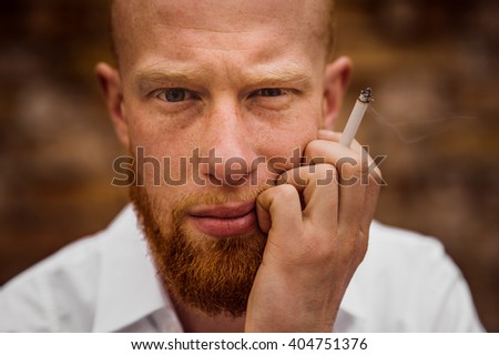 portrait of young bearded red hair man with sigaret  horizontal