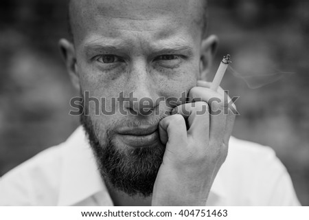 portrait of young bearded red hair man with sigaret black and white horizontal