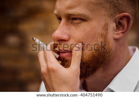 portrait of young bearded red hair man with sigaret  horizontal