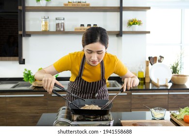 Portrait young beautifu lovely woman standing in kitchen smell food stake for family while cooking. cooking food steak vegetables healthy work at home stay at home for save concept. - Powered by Shutterstock