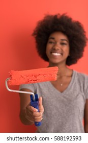 Portrait Of A Young Beautiful African American Woman Painting Wall In Her New Apartment