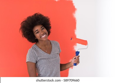 Portrait Of A Young Beautiful African American Woman Painting Wall In Her New Apartment