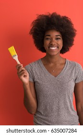 Portrait Of A Young Beautiful African American Woman Painting Wall In Her New Apartment