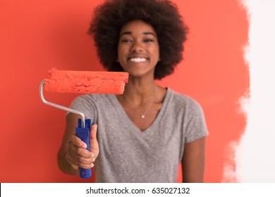 Portrait Of A Young Beautiful African American Woman Painting Wall In Her New Apartment