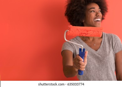 Portrait Of A Young Beautiful African American Woman Painting Wall In Her New Apartment