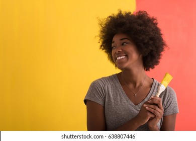 Portrait Of A Young Beautiful African American Woman Painting Wall In Her New Apartment