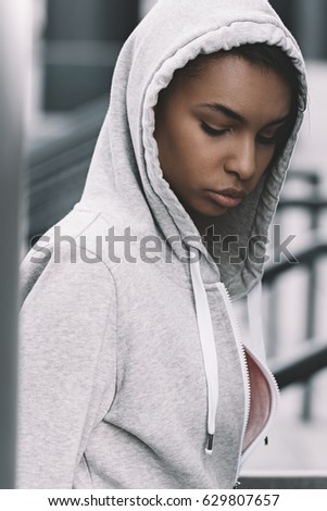 Portrait of young beautiful african american woman in sportswear looking down