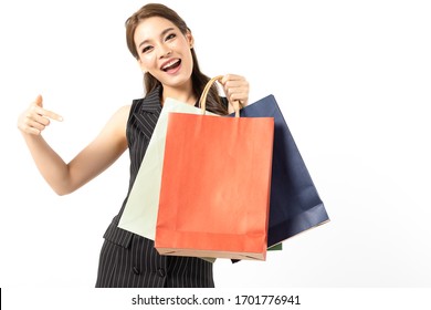 Portrait of young beautiful asian girl wearing black dress holding shopping bags and smile isolated over white background. Online shopping and black friday concept.