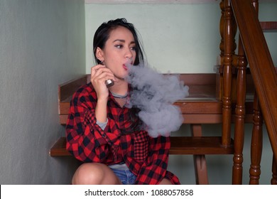 Portrait Of Young Beautiful Asian Woman Vaping At Home