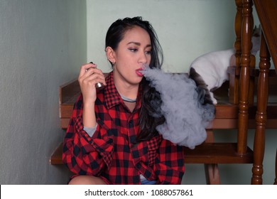 Portrait Of Young Beautiful Asian Woman Vaping At Home