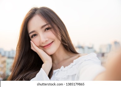 Portrait of young beautiful asian woman  using smart phone selfie live in roof top. Happy asian girl online influencer blogger. Education technology connected asia people, woman lifestyle concept
