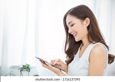 Portrait of young beautiful asian woman relax use smartphone gadget in bedroom. Smile happy asian girl online shopping work from home. Education e-commerce freelance technology connected asia people