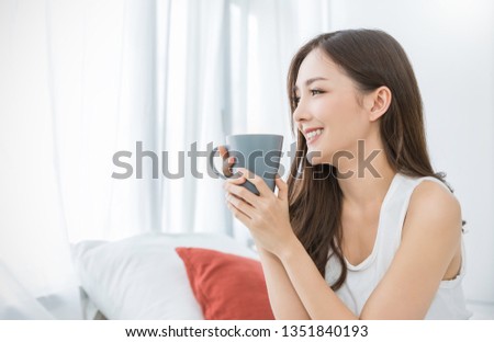 Portrait of young beautiful asian woman hands holding coffee cup morning spring time in white bedroom. Happy cheerful relaxing in summer. Korean makeup wakeup university asia lifestyle concept.