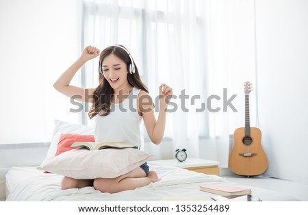 Portrait of young beautiful asian woman relax listen to music sing and dance from headphone in bedroom. Smile happy asian girl relaxing knowledge education university lifestyle, back to school concept