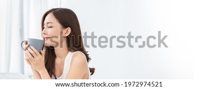Portrait of young beautiful asian woman hands holding coffee cup morning spring time in white bedroom. Happy cheerful relaxing in summer. Korean makeup wakeup university asia lifestyle banner