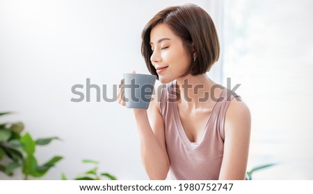 Portrait of young beautiful asian woman hands holding coffee cup morning spring time in white bedroom. Happy cheerful relaxing in summer. Korean asian makeup wakeup university asia lifestyle concept