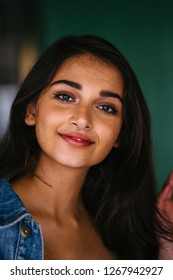 Portrait of a young, beautiful and attractive Indian Asian woman in a stylish retro denim jacket over a white top and blue skirt. She is smiling happily and confidently as she poses for her portrait. - Shutterstock ID 1267942927