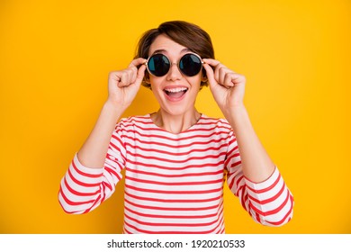 Portrait of young beautiful attractive lovely happy excited smiling girl in sunglasses isolated on yellow color background