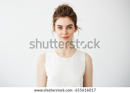 Portrait of young beautiful brunette girl smiling looking at camera over white background.