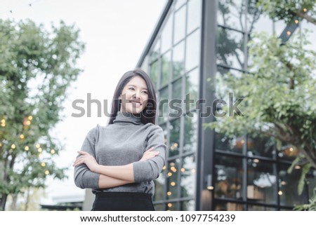 Portrait of young beautiful business woman in the office. Crossed arms