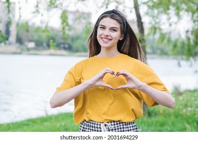 Portrait Of A Young And Beautiful Caucasian Girl Showing Heart Sign