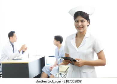 Portrait Of Young Beautiful Cheerful Female Nurse Smiling With Doctor Nurse And Patient Interaction Together On The Background