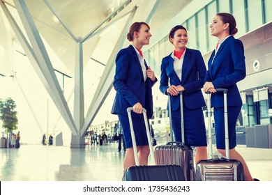 Portrait Of Young Beautiful Confident Flight Attendants Talking In Airport
