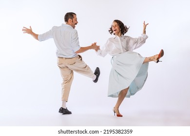 Portrait of young beautiful couple, man and woman, dancing retro dance isolated on white studio background. Enjoyment. Concept of vintage fashion, hobby, activity, art, music, party, creativity and - Powered by Shutterstock