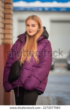 Portrait of a young beautiful fair-haired girl on a spring street.