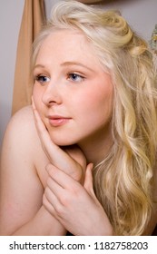 Portrait Of A Young Beautiful Girl With Blue Eyes And Blonde Hair Daydreaming In Her Boudoir 