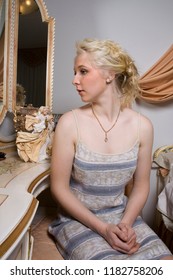 Portrait Of A Young Beautiful Girl With Blue Eyes And Blonde Hair Daydreaming In Her Boudoir 