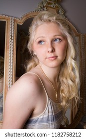 Portrait Of A Young Beautiful Girl With Blue Eyes And Blonde Hair Daydreaming In Her Boudoir 