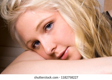 Portrait Of A Young Beautiful Girl With Blue Eyes And Blonde Hair Daydreaming In Her Boudoir 