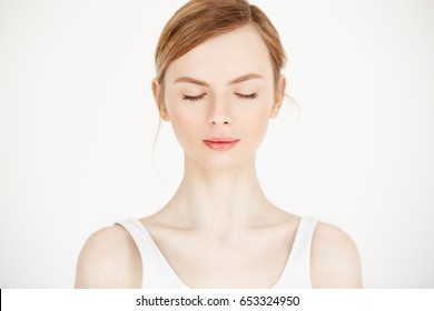 Portrait of young beautiful girl with clean fresh skin isolated on white background. Closed eyes. Beauty and health lifestyle.