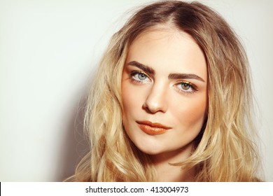 Portrait of young beautiful girl with long messy hair and golden make-up