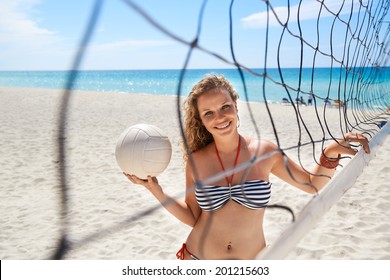Portrait of young beautiful girl vacationing in Varadero, Cuba, playing beach volley near the sea