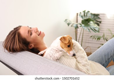 Portrait Of Young Beautiful Hipster Woman With Her Adorable Four Months Old Jack Russell Terrier Puppy At Home In Living Room Full Of Natural Sunlight. Lofty Interior Background, Close Up, Copy Space.