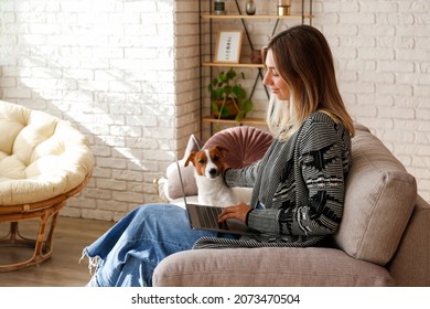 Portrait Of Young Beautiful Hipster Woman Working At Home With Her Adorable Jack Russell Terrier Puppy At Home In Living Room Full Of Natural Sunlight. Lofty Interior Background, Close Up, Copy Space.