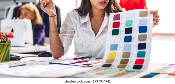 Portrait Of Young Beautiful Pretty Woman Fashion Designer Stylish Stand And Working With Color Textile Samples.Attractive  Senior Woman Working With Mannequins And Colorful Fabrics At Fashion Studio