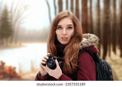Portrait of young beautiful redhead girl taking photo on landscape, Ecstatic young lady, camera in hand, capturing the magic of the autumn forest through her lens.