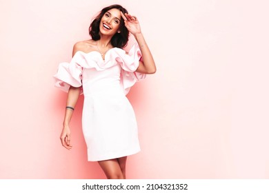 Portrait Of Young Beautiful Smiling Female In Trendy Summer Pink Dress. Sexy Carefree Brunette Woman Posing Near Wall In Studio. Positive Model Having Fun And Laughing. Cheerful And Happy 