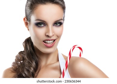 Portrait of young beautiful smiling happy girl with stylish make-up and hairdo, candy canes in hands