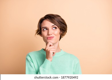 Portrait of young beautiful smiling thoughtful dreamy girl look copyspace think hold hand chin isolated on beige color background - Shutterstock ID 1877920492
