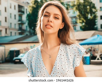 Portrait of young beautiful smiling woman in trendy summer sundress.Sexy carefree woman posing on the street background at sunset. Positive model outdoors