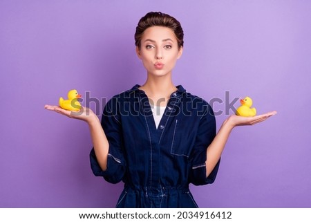 Portrait of young beautiful stunning positive girl hold rubber ducks prepare to bathe isolated on violet color background