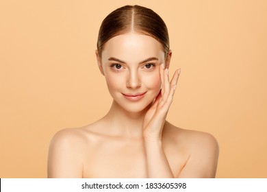 Portrait Of Young Beautiful Woman With Brown Eyes And Glowing Skin, Isolated On Beige Background. Skincare Concept